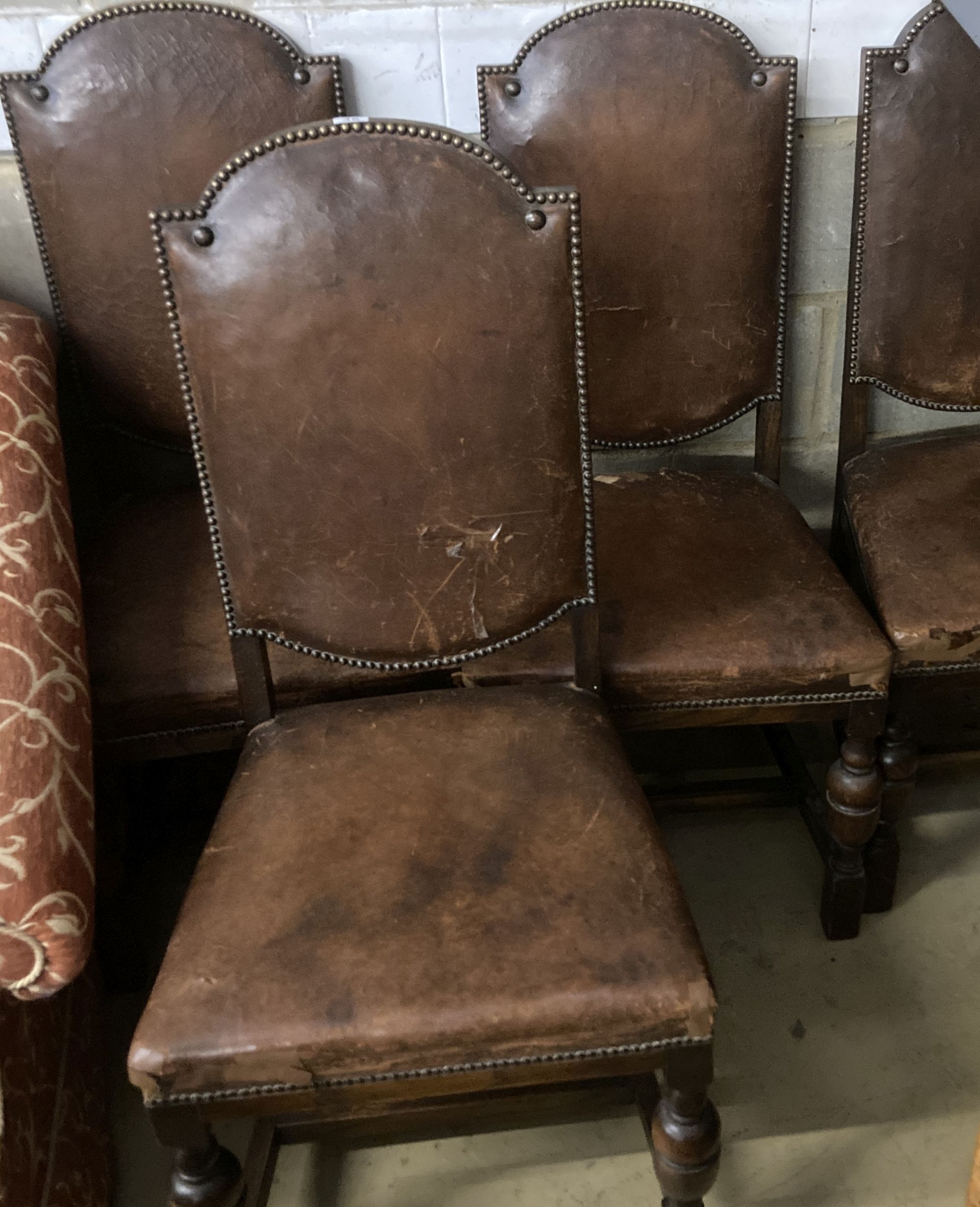 A set of four 1920s oak and tan leather dining chairs, height 109cm
